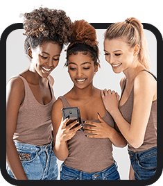 Three young women looking at their cell phones, inclusive employment.