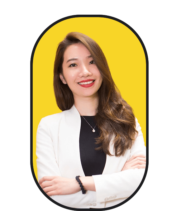 An asian woman looking to hire posing with her arms crossed in front of a yellow background.